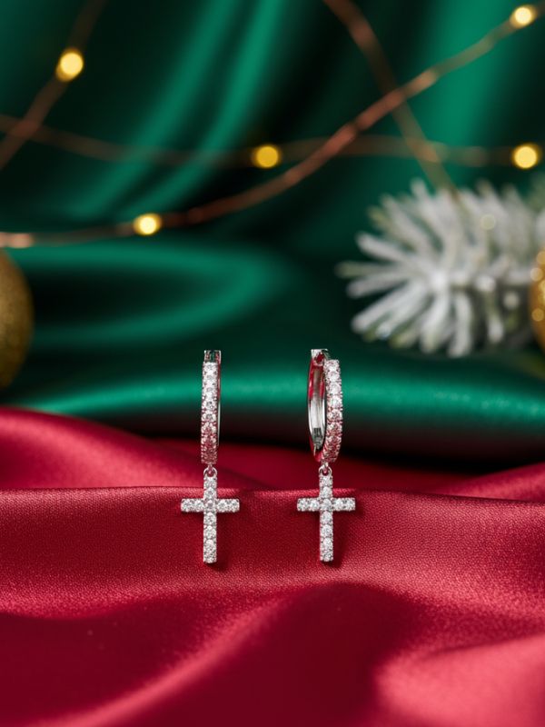 Cross-shaped AuDiam 18K gold diamond cross huggies earrings Christmas gift for her on a red fabric with a festive background