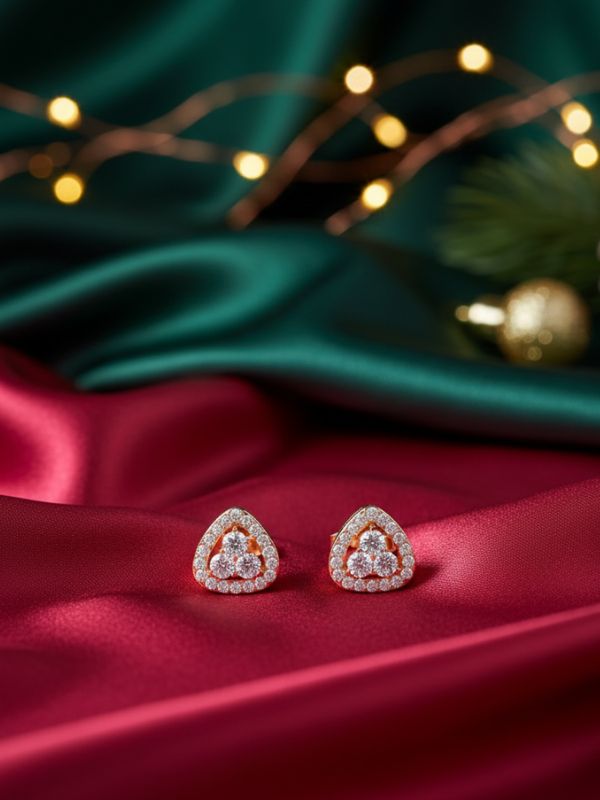 AuDiam minimalist-3-stone-diamond-triangle-1 earrings – Christmas gift for her on a red fabric with green satin and string lights in the background